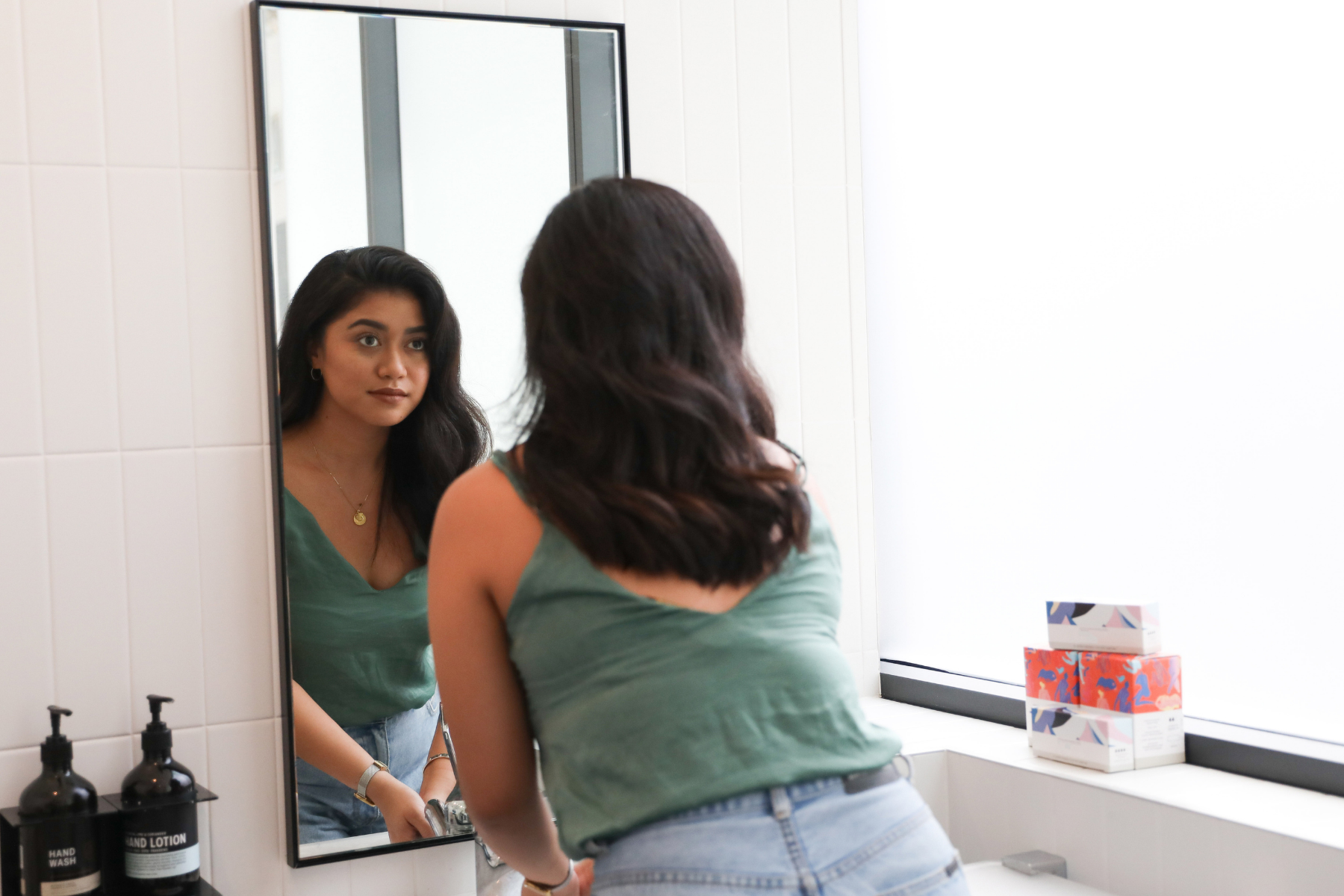 sieviete, kas skatās spogulī, lai apzinātos savu spēku